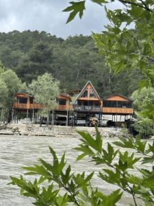 a house on the shore of a river at Rio Adventures Rafting Köprülü Kanyon Konaklama in Karabük