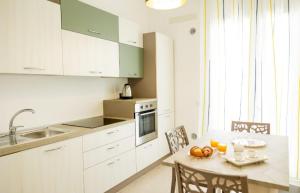 a kitchen with white cabinets and a table and chairs at B&B Terre del cretto in Nuova Gibellina