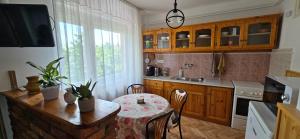a kitchen with a wooden table and a table with a tablecloth at Anna Apartman in Balatonfüred