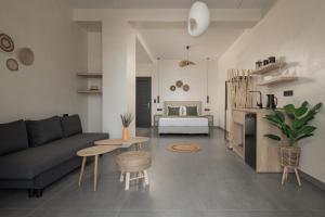 a living room with a couch and a table and a bed at Nuovo Suites-Central Stay With Private Parking in Neos Marmaras