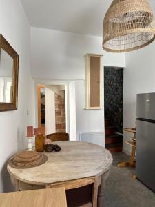 a kitchen with a wooden table and a refrigerator at La Maisonnette in Nîmes