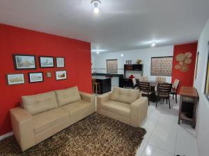 a living room with a couch and a dining room at Aconchegante Casa em Gravatá in Gravatá