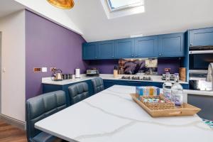 a kitchen with a table and blue cabinets at Central Windsor Luxury 3 Bedroom - Spectacular Social Kitchen and Lounge in Windsor