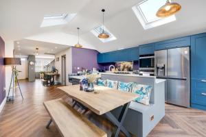 a kitchen with blue cabinets and a wooden table at Central Windsor Luxury 3 Bedroom - Spectacular Social Kitchen and Lounge in Windsor