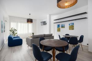 a living room with a couch and tables and chairs at Hotel Levante Cesenatico in Cesenatico