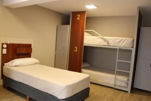 a room with two beds and a bunk bed at Nómade Hostel mdz in Mendoza
