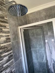 a bathroom with a shower and a ceiling at Hulley Homes- Escape to Beautiful Mountain Views in Umtali +15 photos