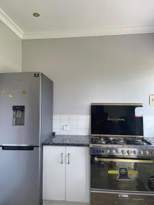 a kitchen with a stove and a refrigerator at Hulley Homes- Escape to Beautiful Mountain Views in Umtali