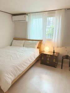 une chambre avec un lit blanc et une fenêtre dans l'établissement 'SUPUL HOUSE' Danggok Station 10 minutes, Free late checkout, à Séoul