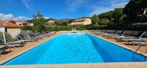 ein Swimmingpool mit Liegestühlen und ein Haus in der Unterkunft Studio Dolce & Vita C2 vue mer avec piscine in Propriano