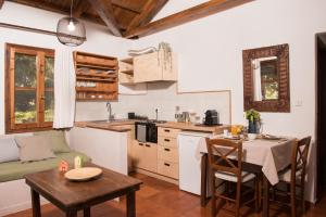 eine Küche und ein Esszimmer mit einem Tisch und einem Esszimmer in der Unterkunft Traganitsa Apartments in Tragána + 23 Fotos