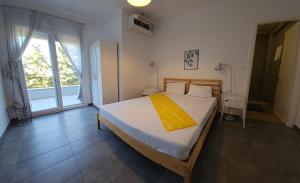 Un dormitorio con una cama con una manta amarilla encima. en Nias Apartments 103, en Keramotí