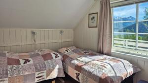 a bedroom with two beds and a window at Sunndalsfjord Cottages Fredsvik Meisalstranda 455,506 og 508 in Sunndalsøra +168 photos