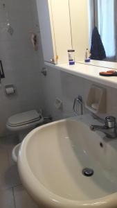 La gazza allegra في Querciola: حمام مع حوض غسيل أبيض ومرحاض +21 صورة