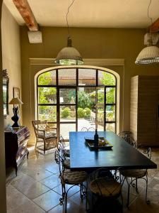 una sala da pranzo con un tavolo e una grande finestra di Grande Maison de Charme a 5 mn du centre ville a Narbonne