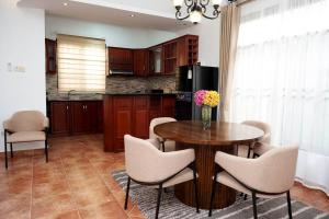 a kitchen with a table and chairs and a kitchen with a refrigerator at Villa Modern Two Bedroom Vacation home in Mbezi Beach in Dar es Salaam