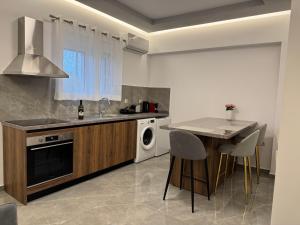 a kitchen with a table and a sink and a dishwasher at CARISSA SUITES a in Afantou