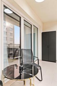 a glass table and a chair on a balcony at InCity Studio - Near Bucharest Mall, Balcony - RH Living in Bucharest