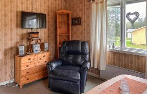 a black leather chair in a room with a television at Mården in Fegen