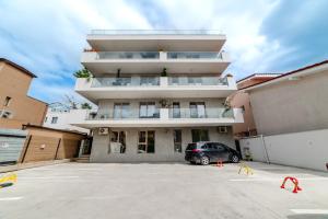 a building with a car parked in a parking lot at Olivia Apartament in Năvodari
