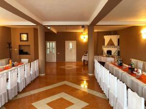 a banquet hall with white tables and white chairs at Casa Dumbrăvița in Sibiu