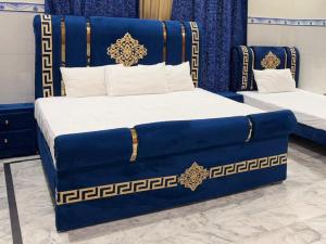 a bed with a blue and gold headboard in a room at Istanbul Inn in Islamabad +12 photos