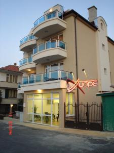 a large building with a sign in front of it at Guest House Hiora in Ahtopol