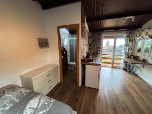 a bedroom with a bed and a desk and a kitchen at Small house in the nature in Granadilla de Abona