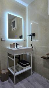 een badkamer met een witte wastafel en een spiegel bij Thethi Sky Lodge in Theth