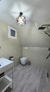 een badkamer met een witte wastafel en een toilet bij Thethi Sky Lodge in Theth +21 foto's