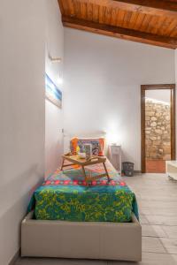 a bedroom with a bed with a table on it at Elsa d'Ortigia - I Tre Archi in Syracuse +17 photos