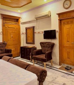 イスラマバードにあるIstanbul Innのベッド1台、椅子2脚、テレビが備わる客室です。