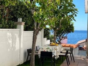 a table and chairs on a patio with the ocean at Espectacular casa frente al mar en Baiona in Baiona