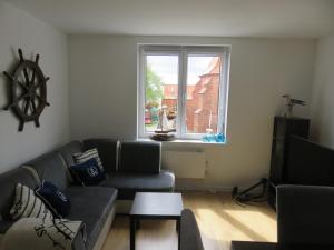 a living room with a couch and a window at Mieszkanie Rybaka na Wiejskiej in Hel