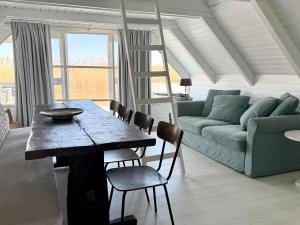a living room with a table and a couch at Seehütte Neusiedlersee inklusive Boot in Rust +36 photos
