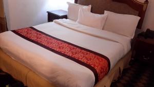 a bedroom with a large bed with white sheets and pillows at Kk Hotel in Addis Ababa