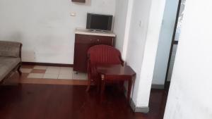 a room with a table and a chair and a television at Kk Hotel in Addis Ababa