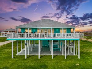 a house with a wrap around porch on a lawn at Blessed 4 Shore Beachfront 4B in Gilchrist