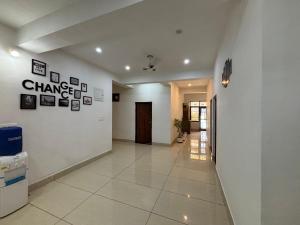 a hallway with a white wall with pictures on it at Pine Haven dharamshala in Dharmsala