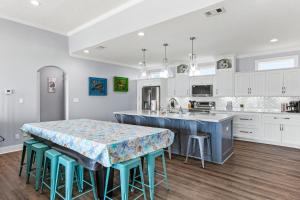 a kitchen with a table and some blue stools at Blessed 4 Shore Beachfront 4B in Gilchrist