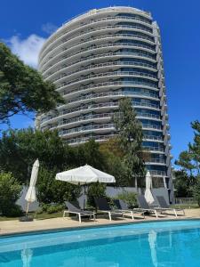 a hotel with a pool and a large building at Apartamentos Torre Tressesenta in Punta del Este +41 photos