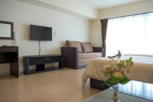 a hotel room with a bed and a couch at Condominium Hotel Monpa in Chatan