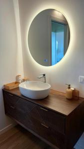 a bathroom with a white sink and a mirror at Brighter Days - Two-room apartment with lake view and pool in Predore