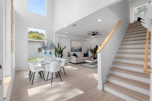 a dining room and living room with a table and stairs at Luxury Modern Comfort in Historic St Augustine in Saint Augustine