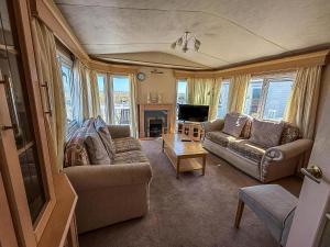 a living room with two couches and a television at 6 Berth Caravan For Hire With Sea Views At Haven Seashore Ref 22087A in Great Yarmouth