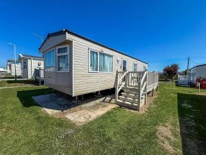 una casa pequeña está sentada en la hierba en Lovely 8 Berth Caravan With Decking At California Cliffs In Norfolk Ref 50015J, en Great Yarmouth