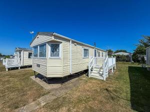 a white tiny house sitting on top of a yard at Stunning Caravan At Cherry Tree Holiday Park In Norfolk, Sleeps 8 Ref 70529C in Great Yarmouth