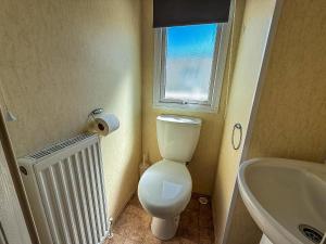 a bathroom with a toilet and a sink and a window at Stunning Caravan At Cherry Tree Holiday Park In Norfolk, Sleeps 8 Ref 70529C in Great Yarmouth +9 photos