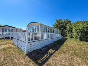 a house with a white fence in a yard at Beautiful 8 Berth Caravan At Cherry Tree Holiday Park In Norfolk Ref 70803C in Great Yarmouth
