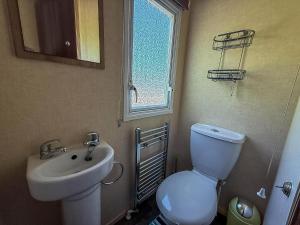 a bathroom with a toilet and a sink and a window at Beautiful 8 Berth Caravan At Cherry Tree Holiday Park In Norfolk Ref 70803C in Great Yarmouth +11 photos